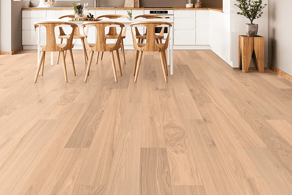 Bright dining area with light-colored hardwood flooring and modern wooden chairs.